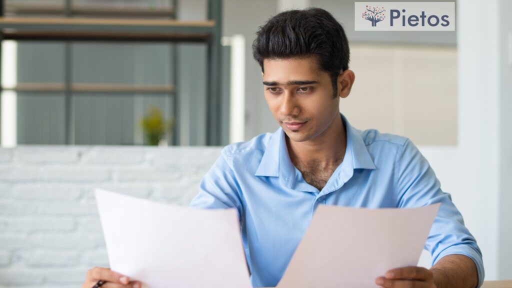 HR manager verifying candidate through magnifying glass with background documents and IDs – background verification in hiring, India